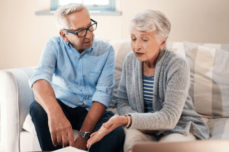 A senior couple discussing their savings in a living room